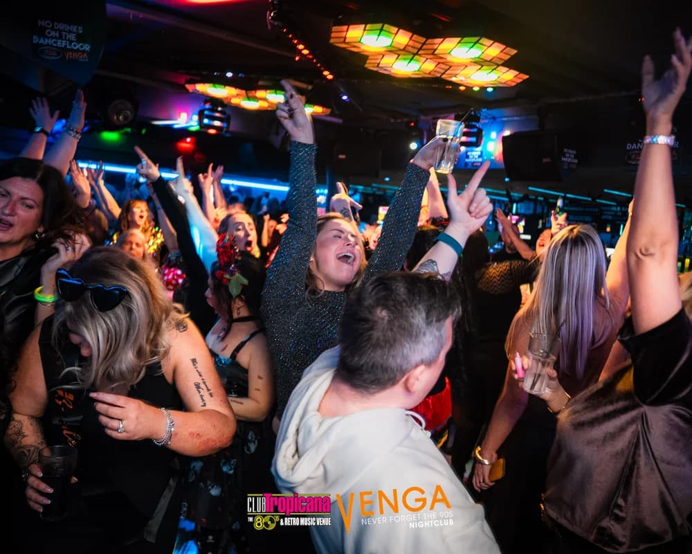 Packed dancefloor with hands raised